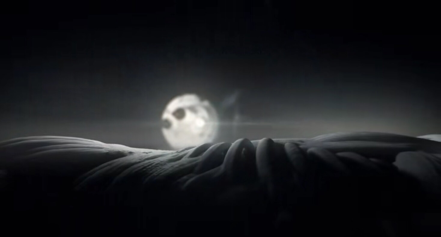 Full moon rising over a textured landscape at night