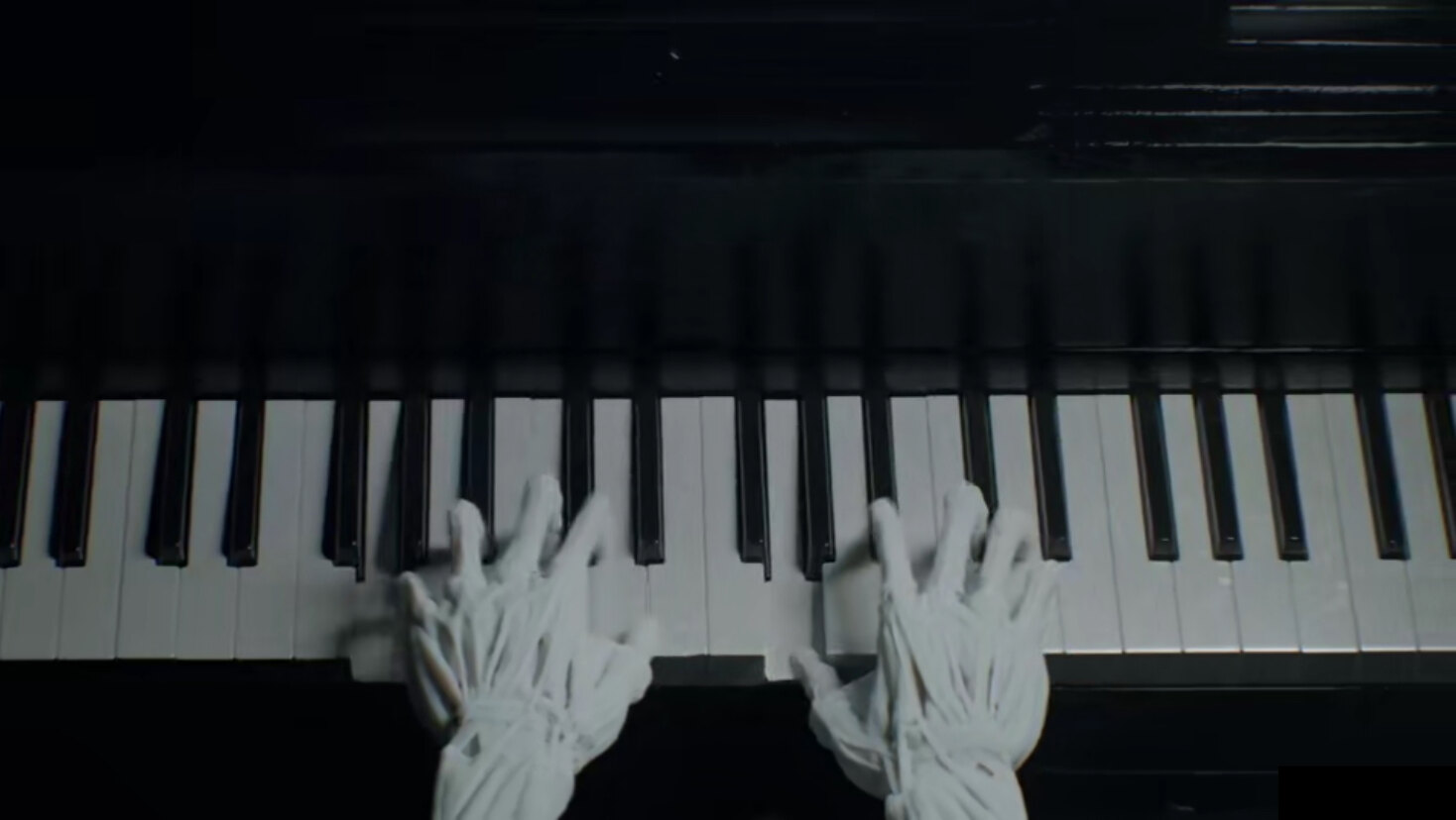 Wrapped hands playing a piano keyboard in black and white
